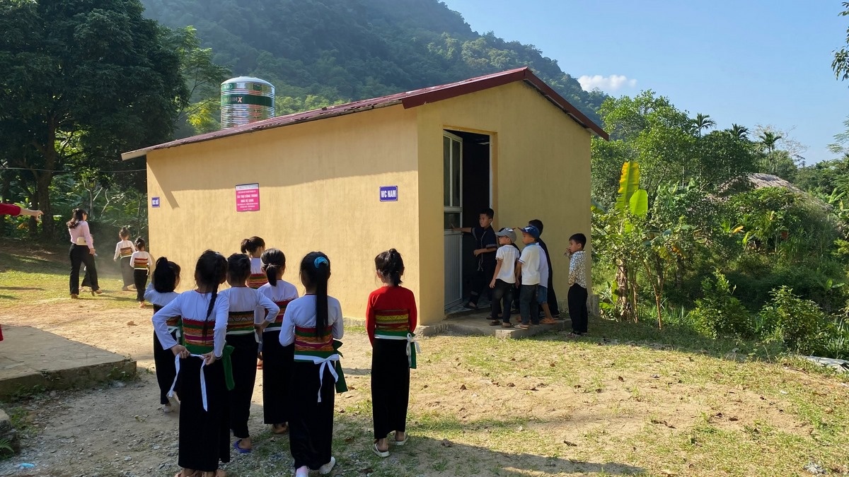 Các em học sinh điểm trường La Ca bên công trình nhà vệ sinh mới do Khối 5 tài trợ