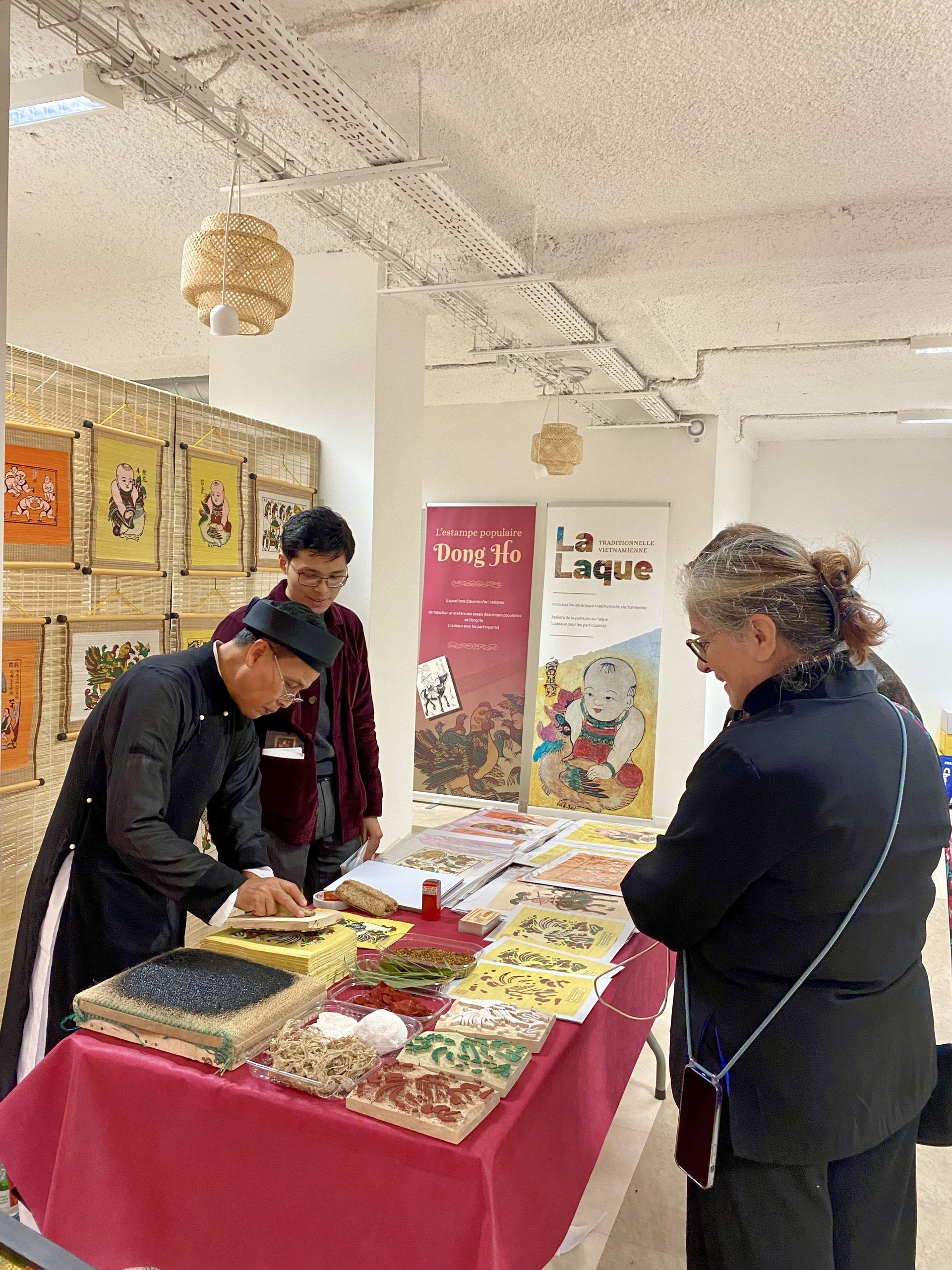 Khách tham dự háo hức tự mình in tranh Đông Hồ dưới sự hướng dẫn của nghệ nhân Nguyễn Đăng Tâm.