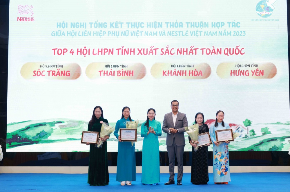 Bà Tôn Ngọc Hạnh, Ủy viên dự khuyết Ban Chấp hành Trung ương Đảng – Phó Chủ tịch Hội LHPN Việt Nam (thứ 3 từ trái qua phải) và Ông Binu Jacob, Tổng giám đốc Nestlé Việt Nam (thứ 4 từ trái qua phải), tuyên dương 4 Hộ