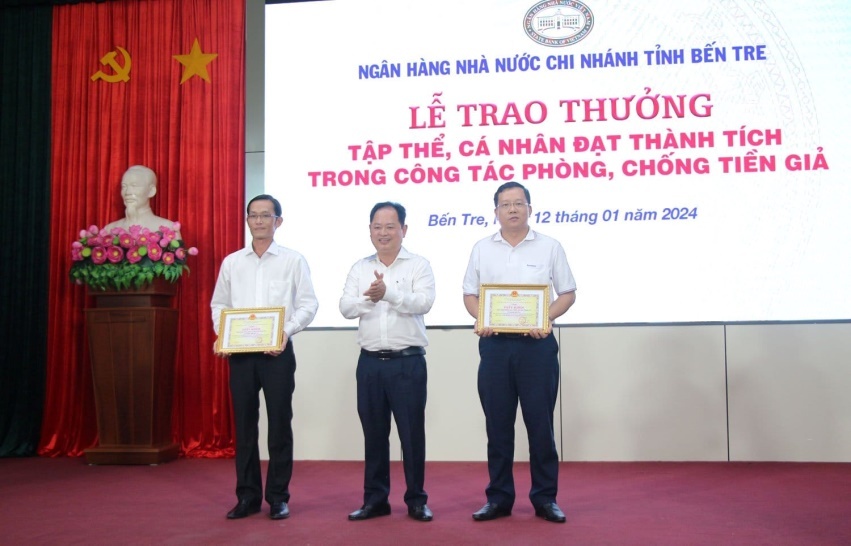 Ông Lê Công Thành - Bí thư Đảng ủy, Giám đốc NHNN tỉnh trao khen thưởng cho 2 tập thể Agribank Bến Tre và Sacombank Bến Tre có thành tích tốt trong công tác phòng chống tội phạm tiền giả