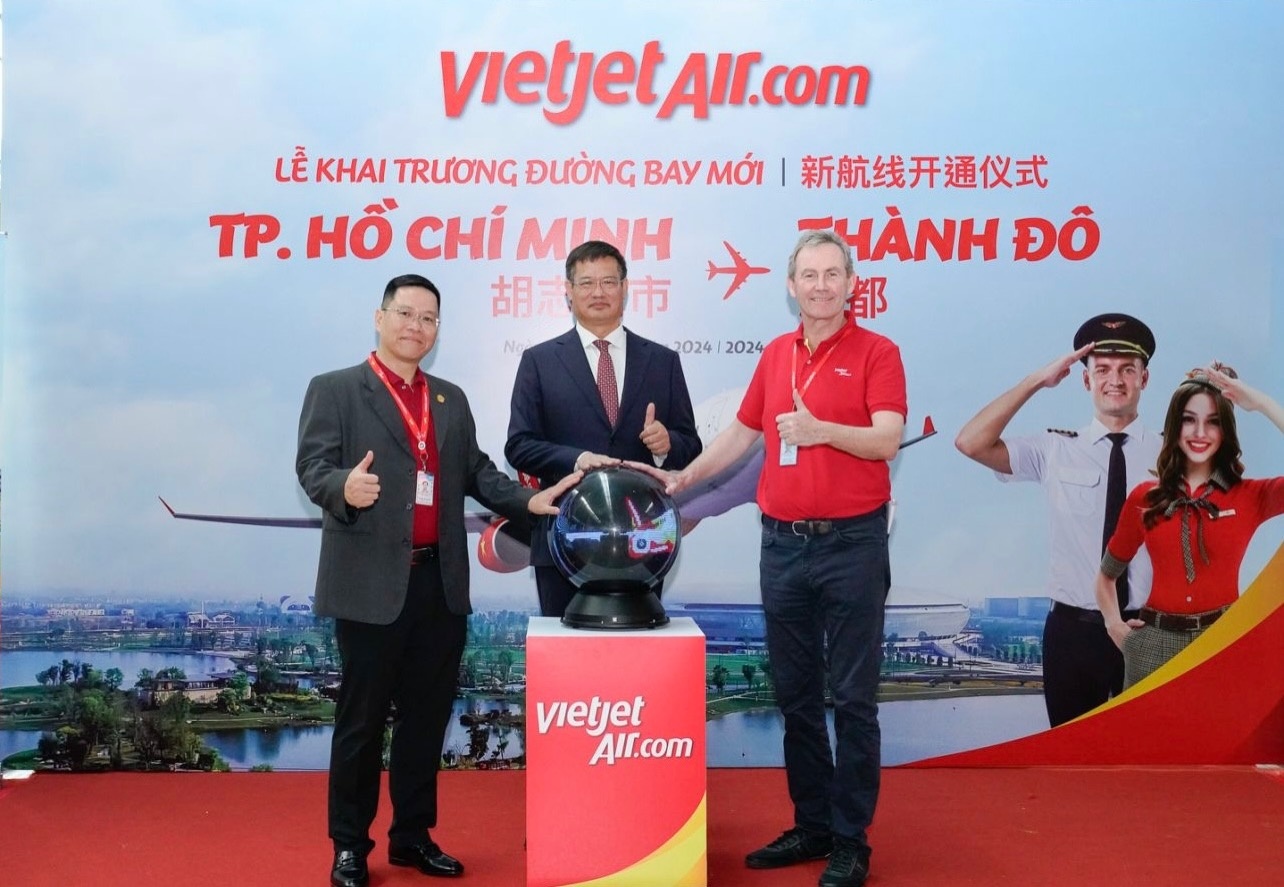Tổng Lãnh sự Trung Quốc tại TP.HCM Ngụy Hoa Tường (giữa) - Phó Tổng giám đốc vận hành Vietjet Micheal Hickey (bên phải ngoài cùng) - Phó Tổng giám đốc thương mại Vietjet Nguyễn Bác Toán (bên trái ngoài cùng) thực hiện nghi thức khai trương đường bay TP. Hồ Chí Minh - Thành Đô.
