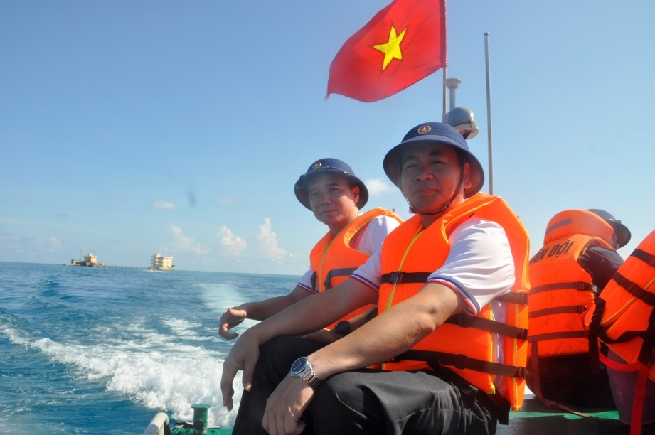 Các thành viên trong đoàn công tác đi ca nô từ tàu vào đảo