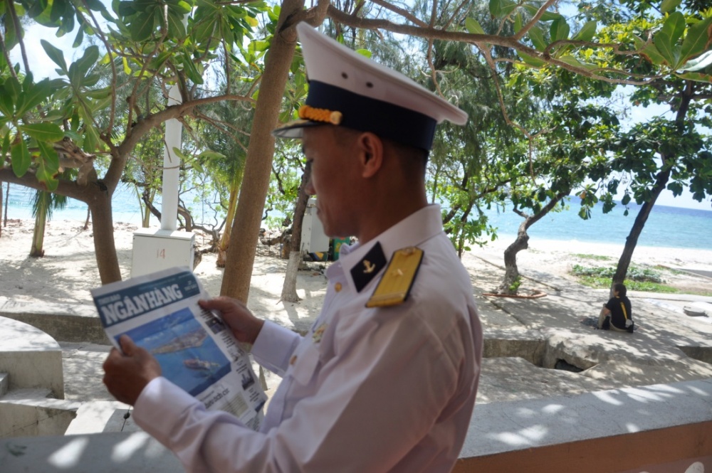 Chiến sĩ đảo tranh thủ đọc báo do phóng viên Thời báo Ngân hàng đi theo đoàn tặng