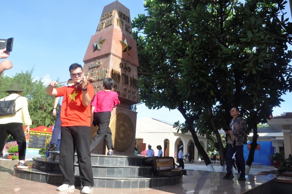 Em Vũ Quang Duy, sinh viên Đại học Kinh tế Quốc dân Hà Nội - thành viên trong đoàn - biểu diễn violon tại đảo Sinh Tồn Đông