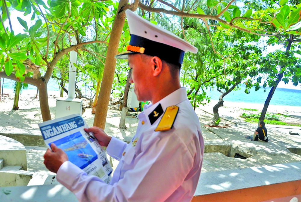 Các chiến sĩ hải quân trên đảo tranh thủ đọc Thời báo Ngân hàng do phóng viên mang theo tặng Các chiến sĩ hải quân trên đảo tranh thủ đọc Thời báo Ngân hàng do phóng viên mang theo tặng