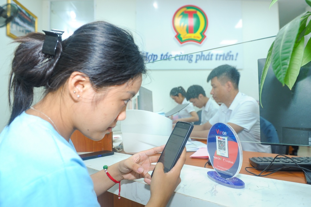 Thành viên của QTDND Ngọc Sơn đang thực hiện giao dịch quét mã QR tại QTDND Ngọc Sơn