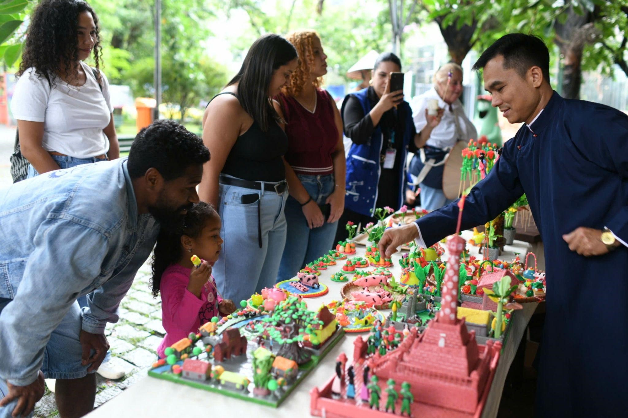 Công chúng Bra-xin tự tay nặn những chiếc Tò he xinh xắn với các hình ảnh quen thuộc như chim Toucan, vũ công samba,… Công chúng Bra-xin tự tay nặn những chiếc Tò he xinh xắn với các hình ảnh quen thuộc như chim Toucan, vũ công samba,…