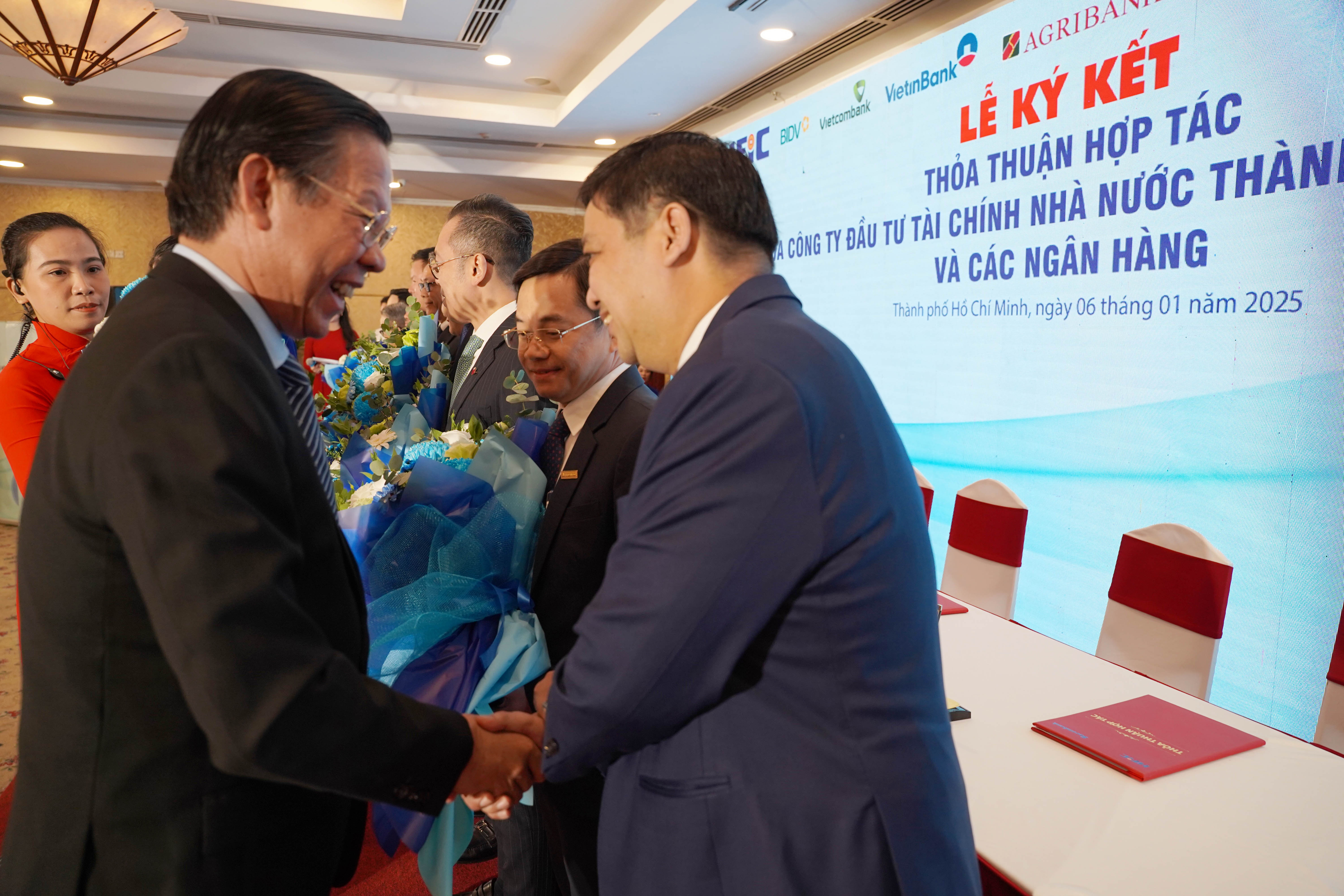 Chủ tịch TP. Hồ Chí Minh – Phan Văn Mãi (bìa trái) tặng hoa, cảm ơn các ngân hàng và đánh giá vốn ngân hàng đóng vai trò quyết định trong phát triển kinh tế thành phố - Ảnh: Đ.Hải