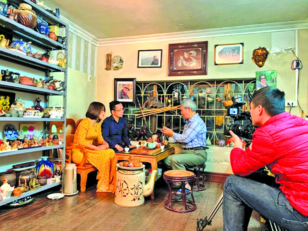 Nhà văn Vương Tâm (áo kẻ) đang giới thiệu với ê kip phóng viên truyền hình về bộ sưu tập đồ gốm tại tư gia Nhà văn Vương Tâm (áo kẻ) đang giới thiệu với ê kip phóng viên truyền hình về bộ sưu tập đồ gốm tại tư gia