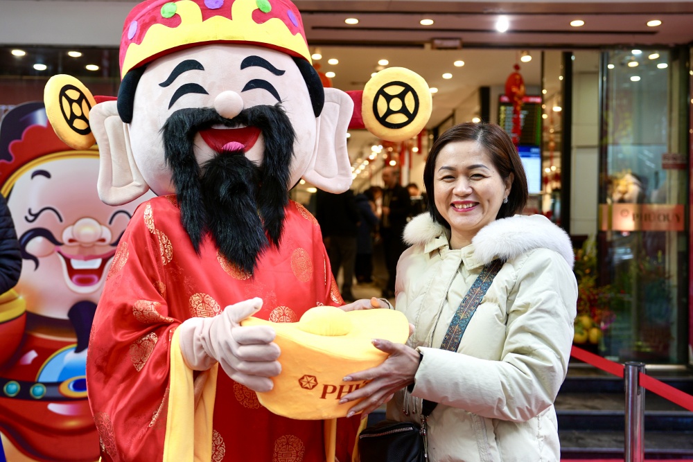 Khách mua hàng chụp ảnh với Thần tài tại cửa hàng Phú Quý Khách mua hàng chụp ảnh với Thần tài tại cửa hàng Phú Quý