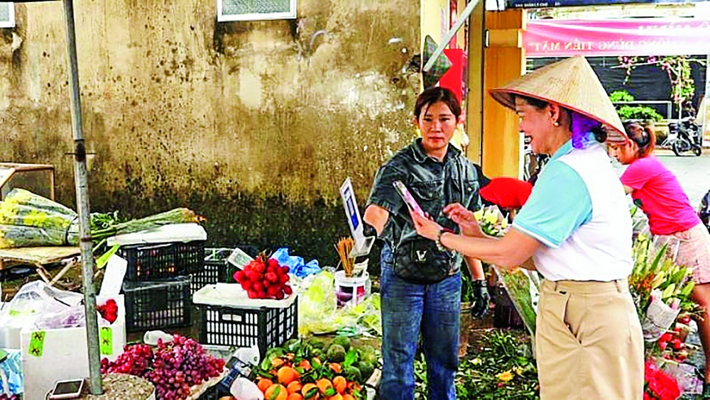 Người dân sử dụng thanh toán bằng quét mã QR tại chợ ngoại thành Hà Nội