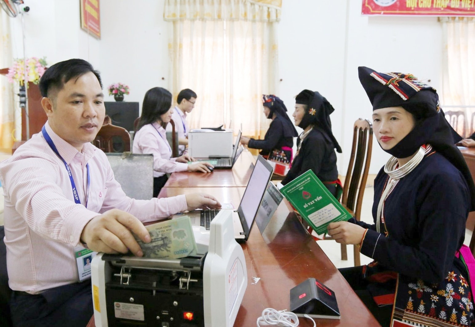 Giải quyết thủ tục vay vốn cho người dân tại Phòng giao dịch Ngân hàng Chính sách xã hội huyện Ba Vì. Ảnh: HNM