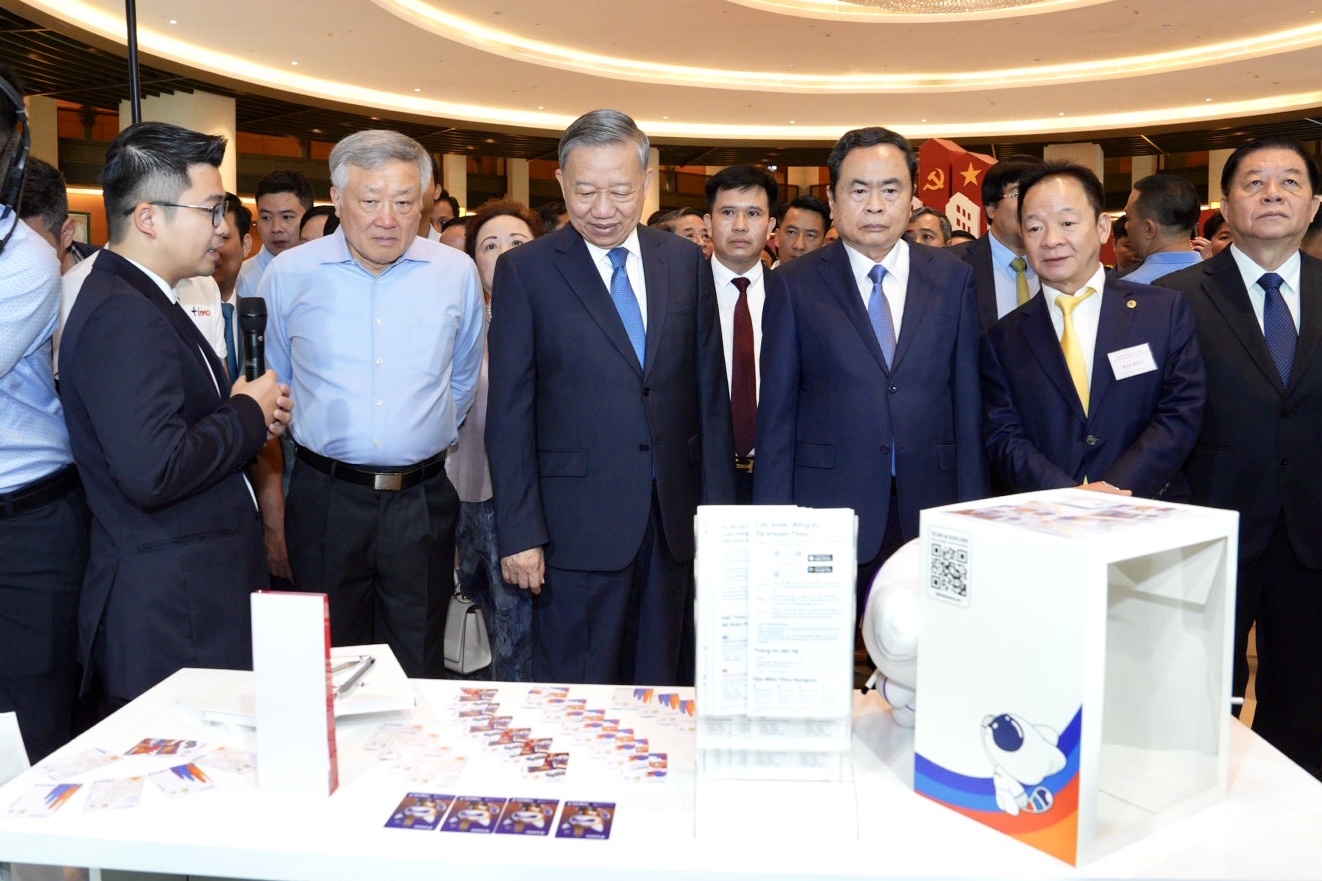 Tổng bí thư Tô Lâm nghe giới thiệu về các loại thẻ ngân hàng tại gian hàng của ngân hàng Bản Việt Bank