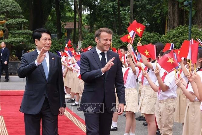 Chủ tịch nước Lương Cường và Tổng thống Pháp Emmanuel Macron với thiếu nhi Thủ đô Hà Nội. Ảnh: TTXVN