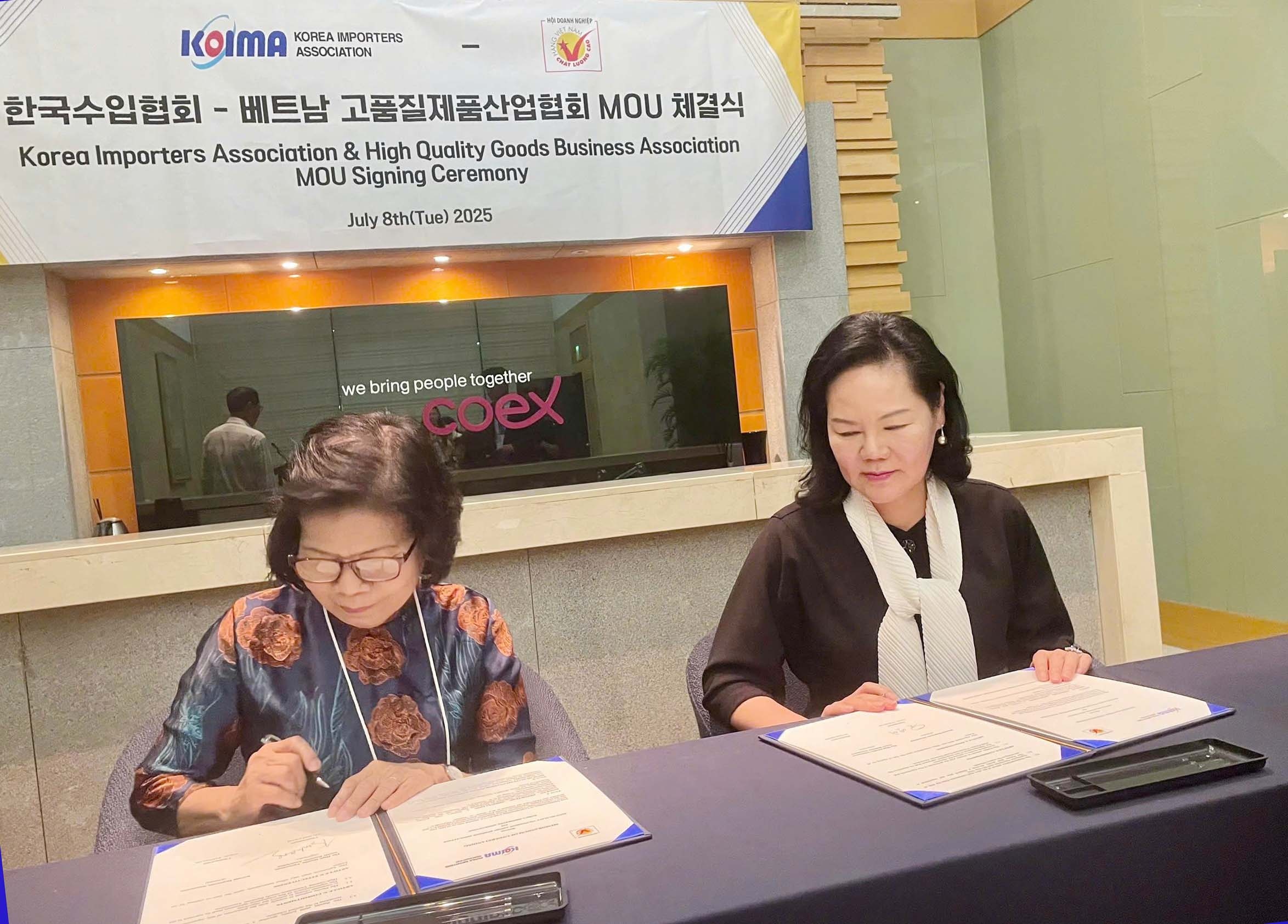 Bà Vũ Kim Hạnh (bìa trái), chủ tịch Hội doanh nghiệp Hàng Việt Nam chất lượng cao ký kết Biên bản Ghi nhớ hợp tác với Hiệp hội các Nhà Nhập khẩu Hàn Quốc (KOIMA) 