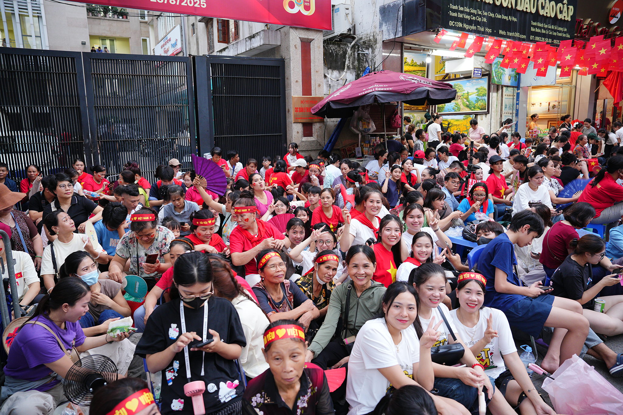 Người lớn, trẻ nhỏ ngồi kín vỉa hè, tạo nên khung cảnh đông đúc trước giờ tổng duyệt A80
