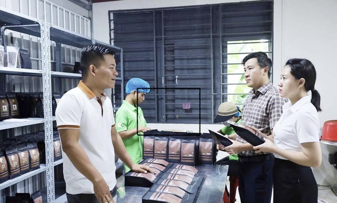 Anh Y Pốt Niê đang chia sẻ với cán bộ tín dụng ngân hàng những sản phẩm được tạo nên từ hạt cà phê canh tác theo hướng an toàn sinh học