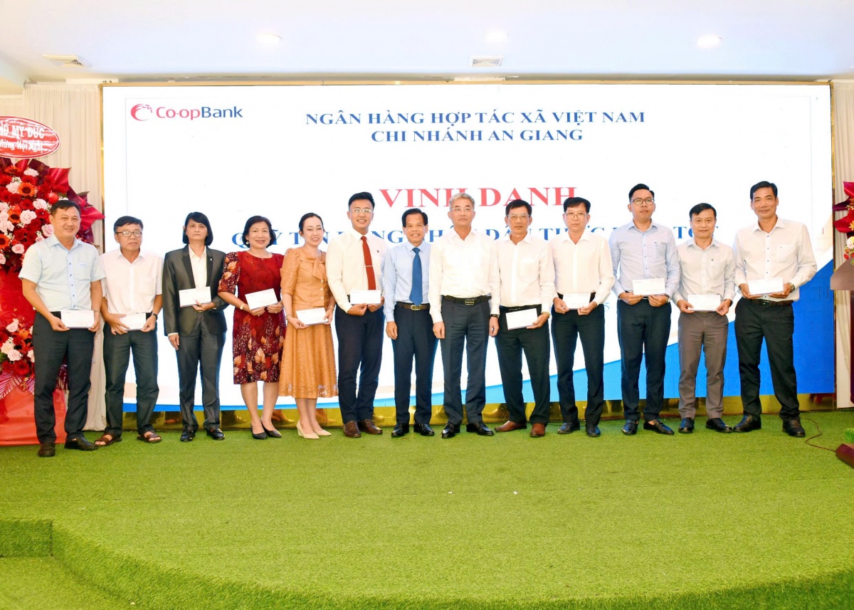 Ông Nguyễn Quốc Cường - Chủ tịch Hội đồng quản trị Co-opBank và ông Đặng Hoàng Ngọ - Giám đốc Co-opBank chi nhánh An Giang trao vinh danh cho các QTDND tại Hội nghị QTDND do Co-opBank chi nhánh An Giang tổ chức
