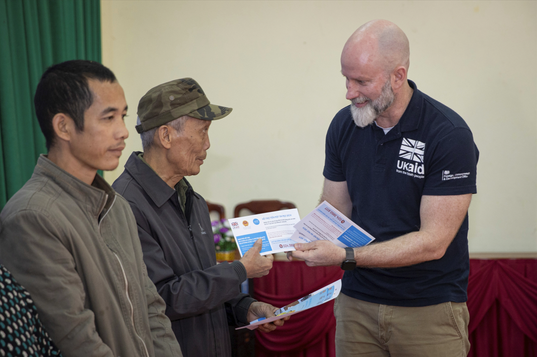 Bí thư Thứ nhất phụ trách Khí hậu và Thiên nhiên - Đại sứ quán Anh, Fergus McBean, trao tiền hỗ trợ cho các hộ gia đình bị ảnh hưởng bởi bão lũ vừa qua tại Lạng Sơn. (Ảnh: UNICEF)