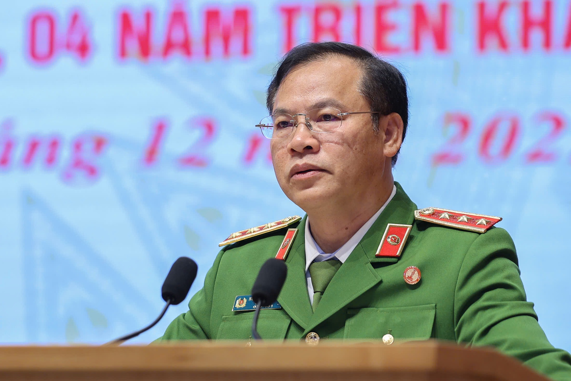 Thứ trưởng Bộ Công an Nguyễn Văn Long trình bày Báo cáo tổng quan về việc triển khai Đề án 06 tại Hội nghị. Ảnh: VGP/Nhật Bắc