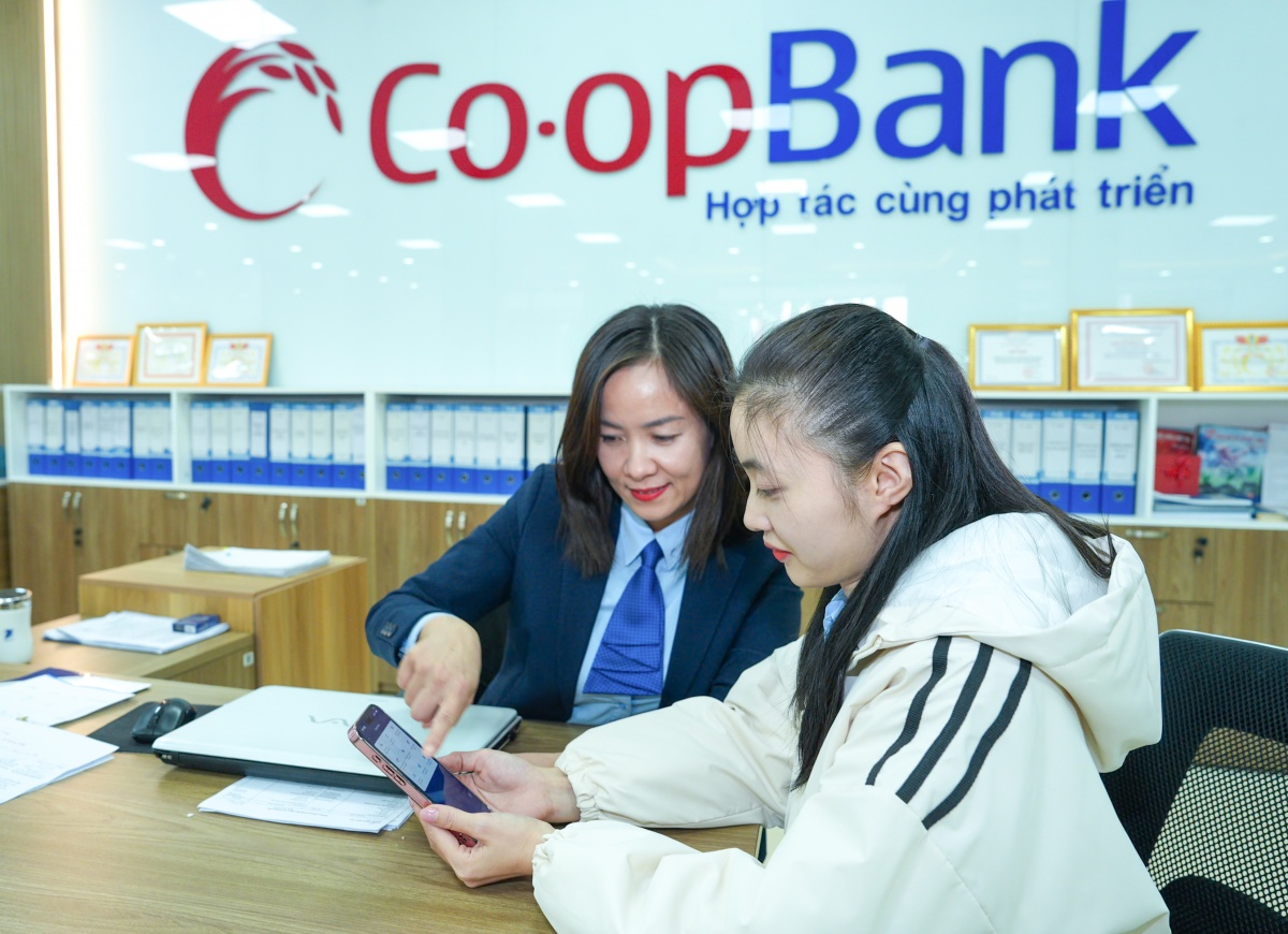 Cán bộ Co-opBank hướng dẫn khách hàng sử dụng dịch vụ Co-opBank Mobile Banking