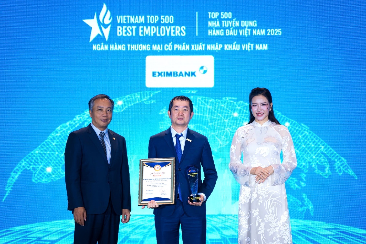Ông Nguyễn Hướng Minh – Phó TGĐ Eximbank (đứng giữa) nhận giải thưởng “Top 10 nơi làm việc tốt nhất Việt Nam 2025” từ Ban tổ chức.
